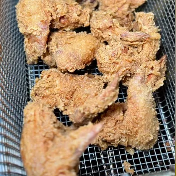 Fried chicken resting on a rack in the Fri Kitchn kitchen.