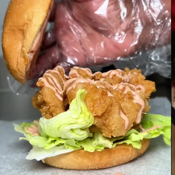 A fried chicken sandwich on a soft bun with lettuce.