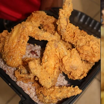 A black tray of Fri Kitchn fried chicken pieces.